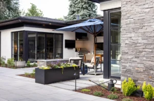 Modern xeriscape patio with an outdoor kitchen, stone hardscaping, and water-wise planting